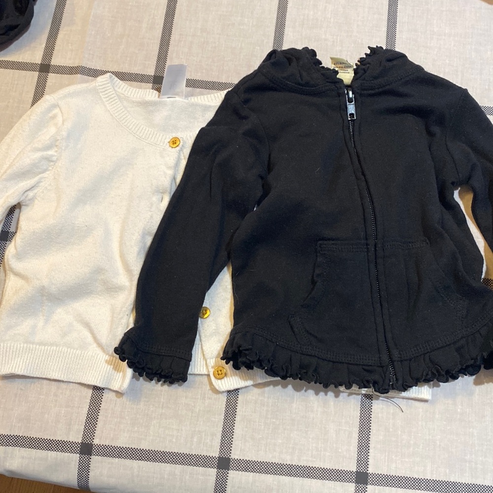 Black- zip up jacket with hood. White cardigan.